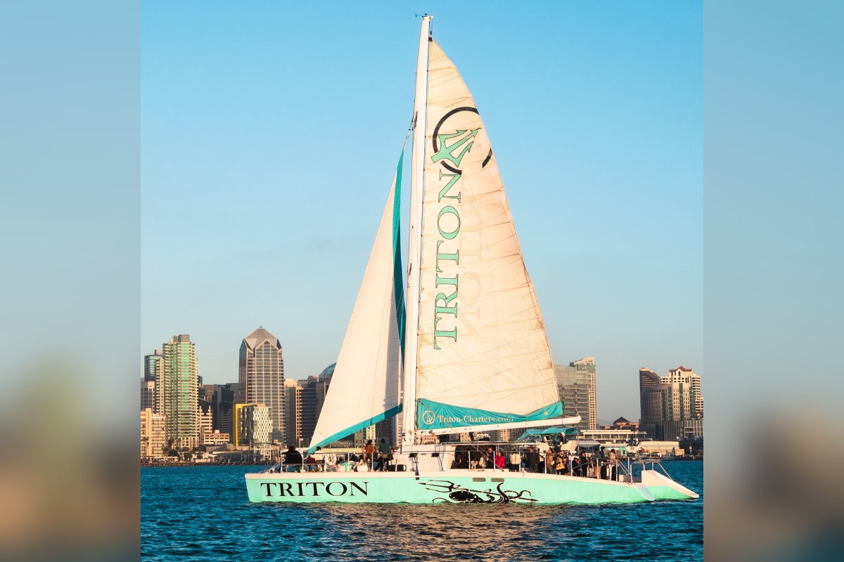 Triton under sail on San Diego Bay with the downtown skyline behind