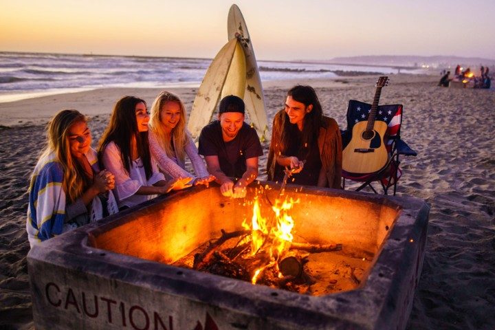 Friends gathered around a beach fire pit
