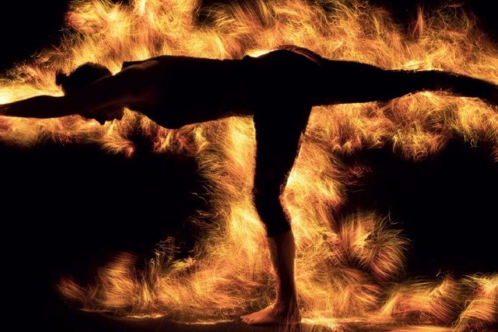 Yoga silhouette against firelight