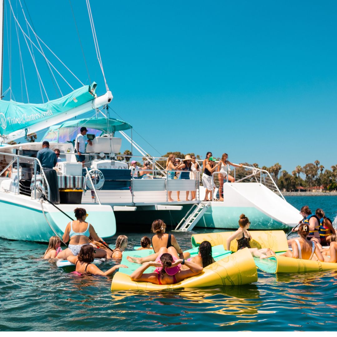 Guests floating on the lily pad beside the catamaran
