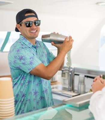 A Triton crew member pouring drinks at the onboard bar