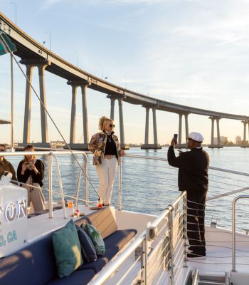 Guests taking photos on deck beneath the Coronado Bridge