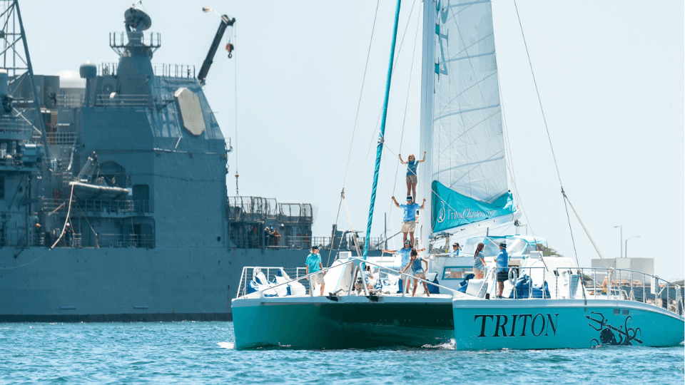 Triton catamaran passing the USS Midway