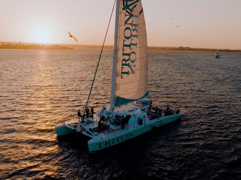 Triton catamaran sailing San Diego Bay at sunset
