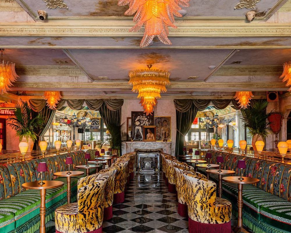 Ornate art-deco dining room at The Lafayette Hotel with chandeliers and green banquettes