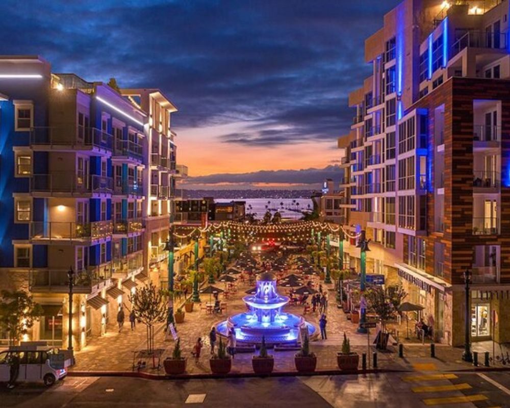 Little Italy at dusk, the Piazza della Famiglia fountain lit up between restaurants