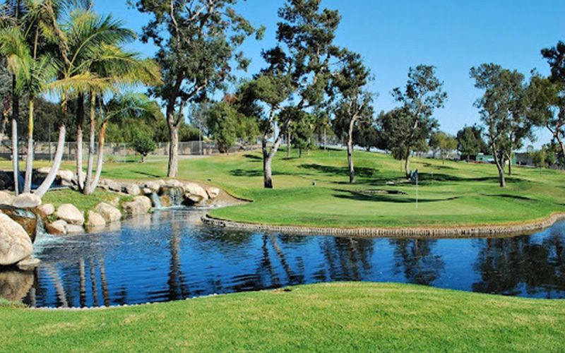 Golf fairway and pond ringed by palm trees on a San Diego course