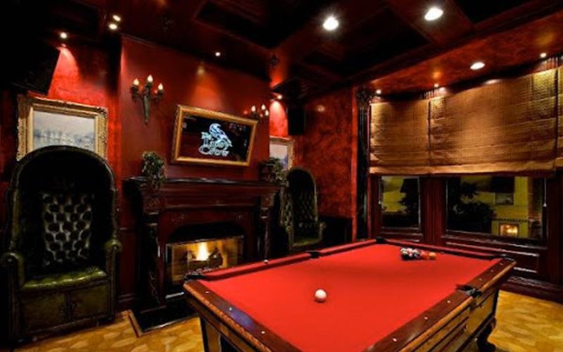 Red-felt pool table in a dark, wood-panelled bar room